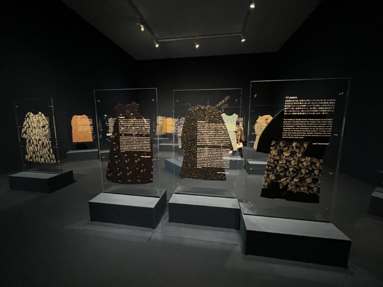 カーテンの奥には、落ち着いた照明に照らされた服とエピソードの数々